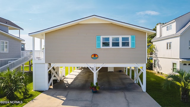 1409 Inlet St, Sunset Beach, NC 28468 - view of front of house featuring a carport, stairs, concrete driveway, and a front lawn
