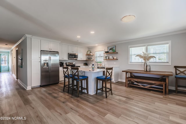 1409 Inlet St, Sunset Beach, NC 28468 - kitchen with appliances with stainless steel finishes, crown molding, open shelves, a kitchen breakfast bar, and baseboards