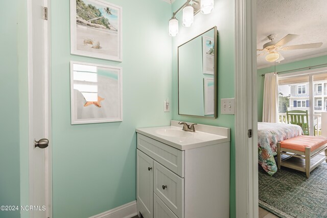 1409 Inlet St, Sunset Beach, NC 28468 - bathroom featuring vanity, a ceiling fan, a textured ceiling, ensuite bath, and baseboards
