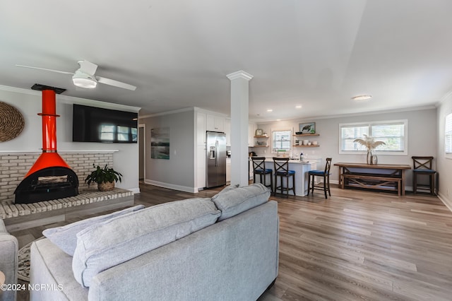 1409 Inlet St, Sunset Beach, NC 28468 - living area featuring ornamental molding, wood finished floors, baseboards, a ceiling fan, and decorative columns