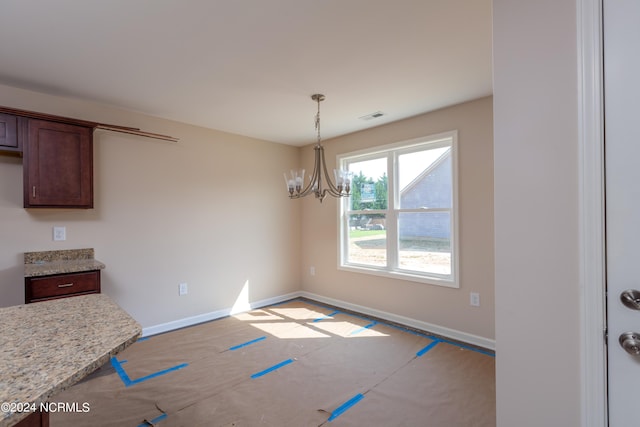 unfurnished dining area with an inviting chandelier