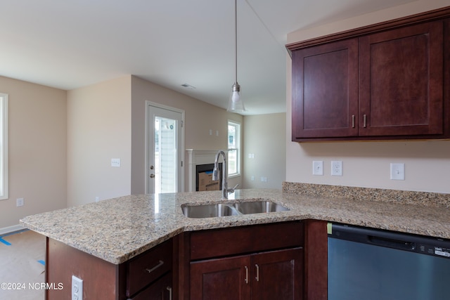 kitchen with sink, light stone countertops, decorative light fixtures, stainless steel dishwasher, and kitchen peninsula