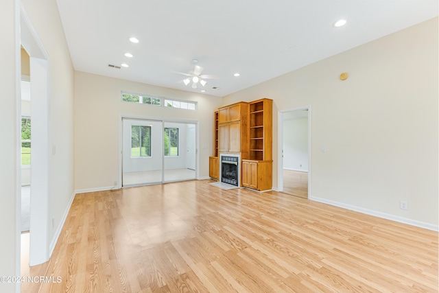 unfurnished living room with ceiling fan and light wood-type flooring