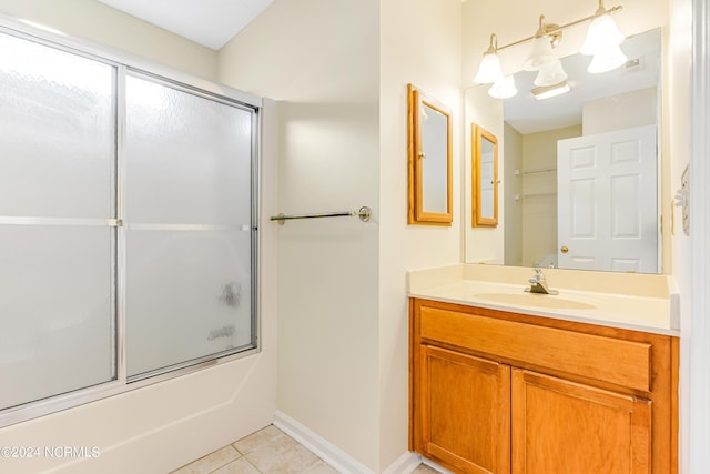 bathroom featuring vanity, tile patterned floors, and enclosed tub / shower combo