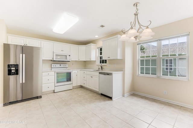 kitchen with white cabinetry, white appliances, decorative light fixtures, and a chandelier