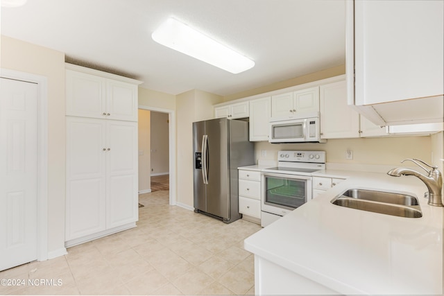 kitchen featuring white cabinetry, sink, and white appliances