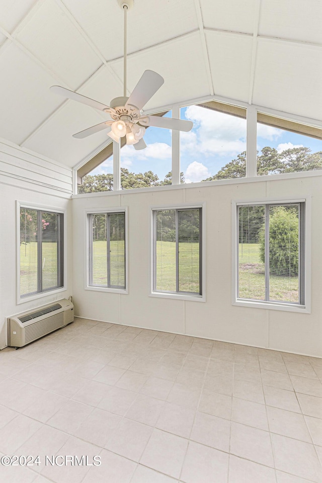 unfurnished sunroom featuring ceiling fan, vaulted ceiling, and a wall unit AC