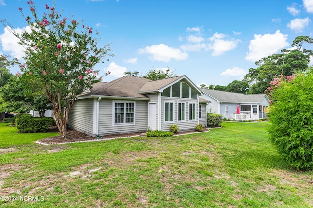 rear view of property featuring a yard