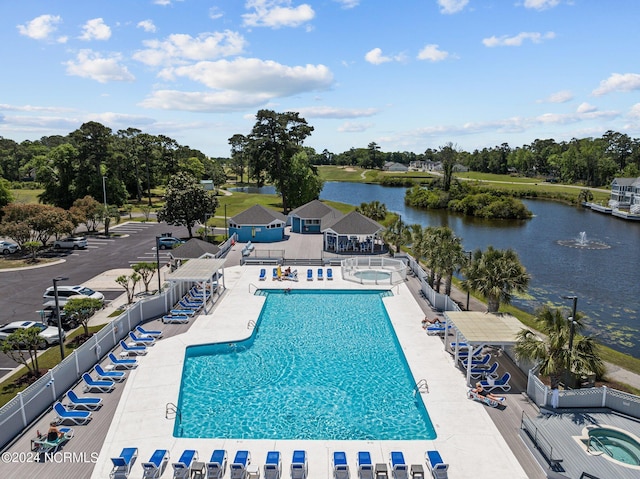 view of swimming pool with a community hot tub, a water view, and a patio area