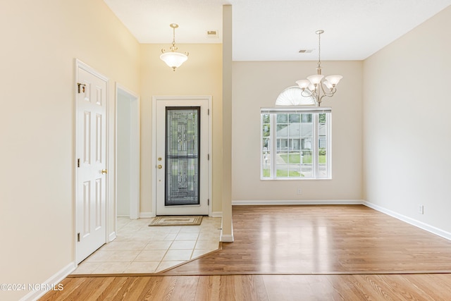 foyer entrance with a chandelier and light hardwood / wood-style flooring