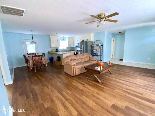 living room featuring sink, light hardwood / wood-style flooring, and ceiling fan