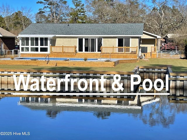 exterior space featuring a water view, a yard, and a sunroom