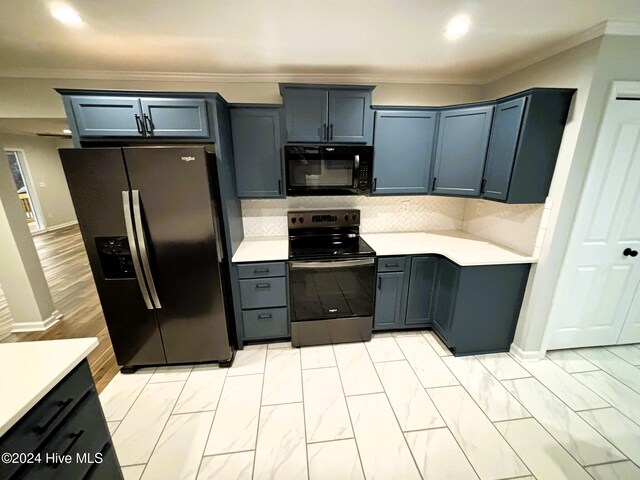 kitchen featuring black appliances, sink, light hardwood / wood-style flooring, a kitchen bar, and kitchen peninsula