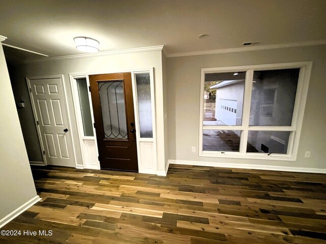 entrance foyer with dark hardwood / wood-style floors and crown molding