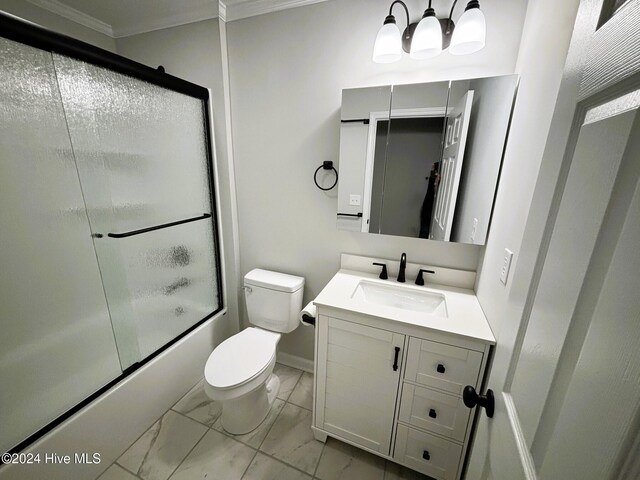 full bathroom featuring toilet, vanity, combined bath / shower with glass door, and ornamental molding