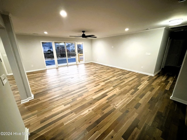 unfurnished room with ornamental molding, dark wood-type flooring, and ceiling fan