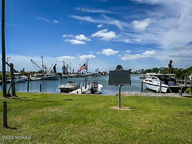 view of dock featuring a water view and a yard