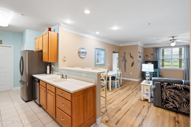 kitchen with sink, light wood-type flooring, ceiling fan, stainless steel dishwasher, and ornamental molding