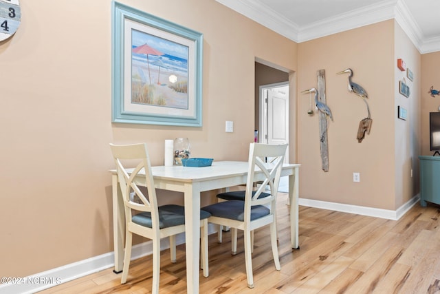 dining area with light wood-type flooring and ornamental molding