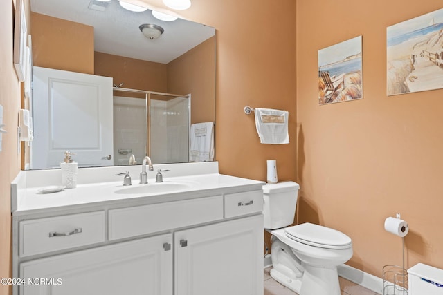 bathroom featuring tile patterned flooring, vanity, toilet, and a shower with door