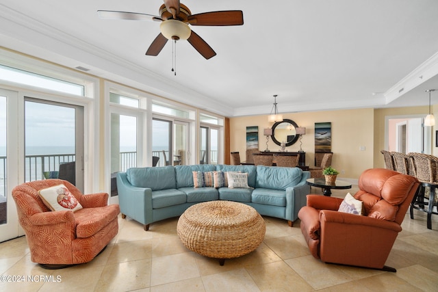 living room featuring plenty of natural light, a water view, and crown molding