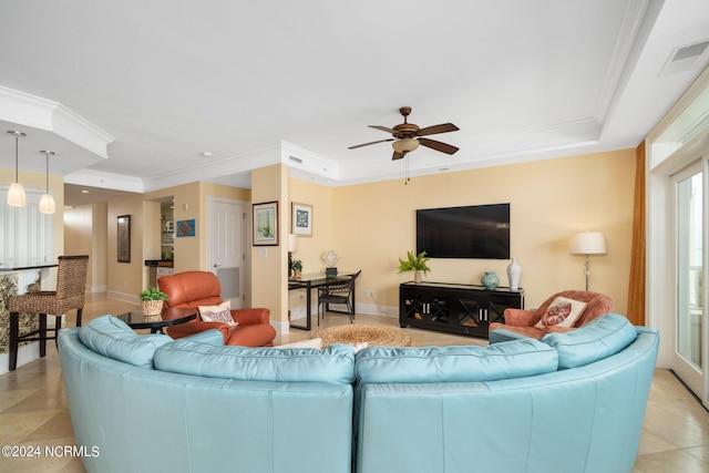 living room with crown molding, ceiling fan, a raised ceiling, and light tile patterned floors