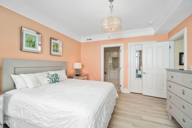 bedroom with connected bathroom, ornamental molding, and light wood-type flooring