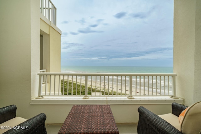 balcony with a water view and a beach view