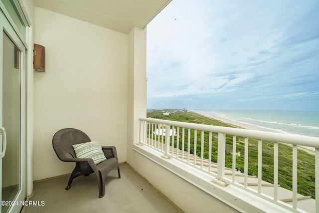 balcony with a water view and a view of the beach