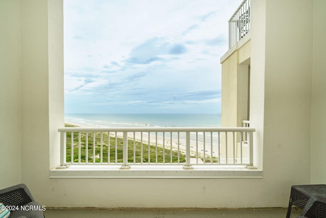 balcony featuring a view of the beach and a water view