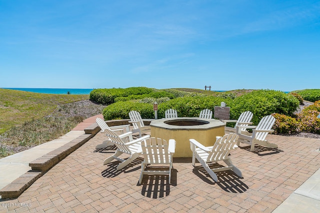 view of patio / terrace featuring a water view and a fire pit