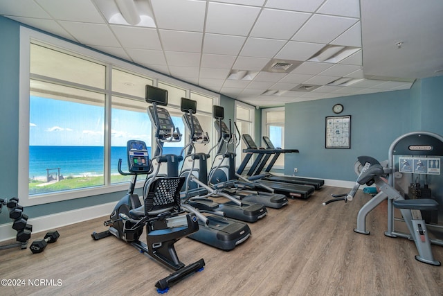 gym with a drop ceiling and hardwood / wood-style floors