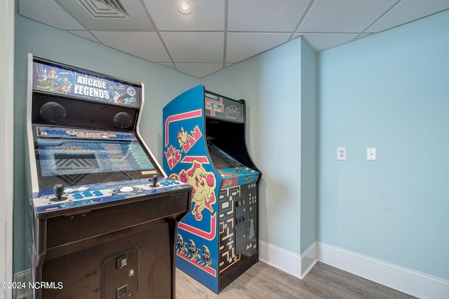 recreation room with a paneled ceiling and hardwood / wood-style flooring