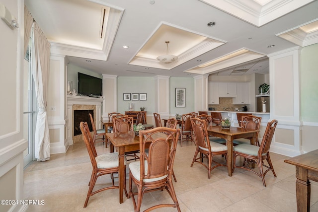 dining space with ornamental molding, light tile patterned floors, and a raised ceiling