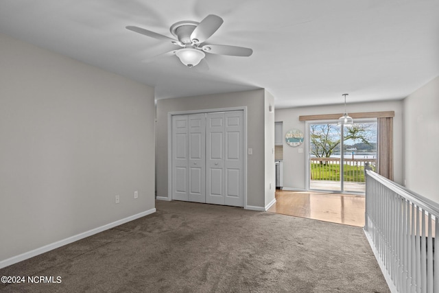 unfurnished bedroom with a closet, access to outside, carpet floors, and ceiling fan