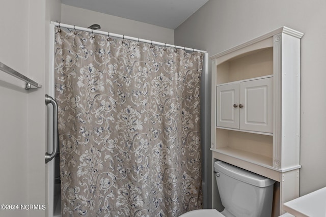 bathroom with a shower with curtain and toilet