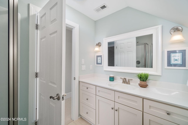 bathroom featuring walk in shower, lofted ceiling, and vanity