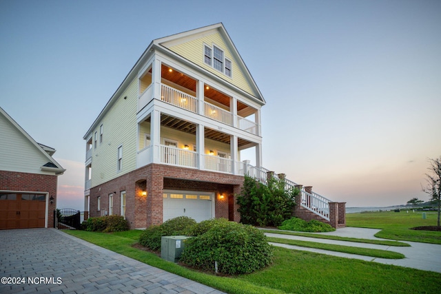 view of front of home featuring a balcony, a garage, and a lawn