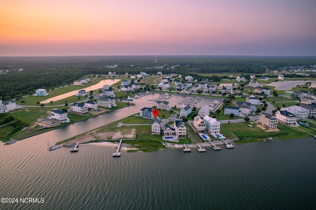 aerial view at dusk featuring a water view