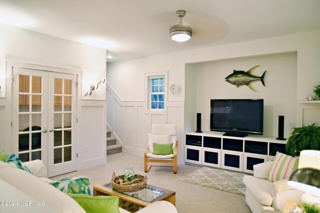 living room featuring light colored carpet, french doors, and ceiling fan