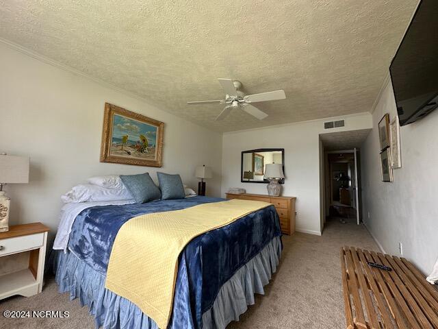 bedroom featuring a textured ceiling, carpet floors, and ceiling fan