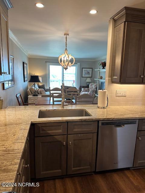 kitchen featuring backsplash, a notable chandelier, ornamental molding, stainless steel dishwasher, and dark hardwood / wood-style floors