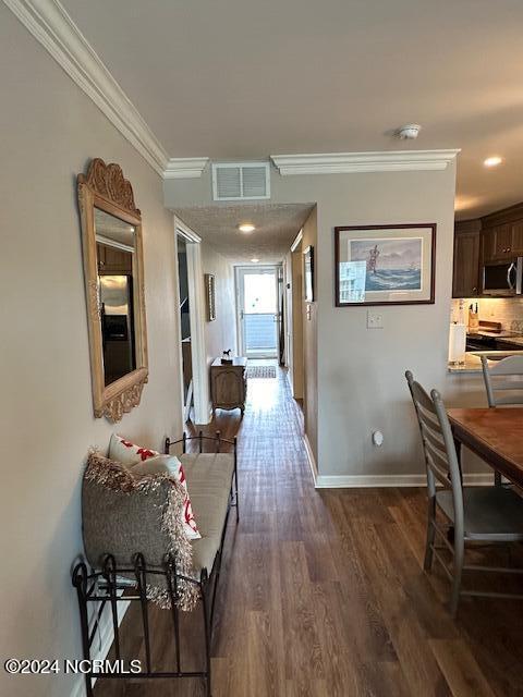 hallway with hardwood / wood-style floors and ornamental molding