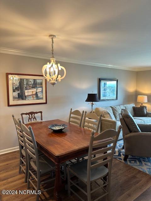 dining room featuring a notable chandelier, dark hardwood / wood-style flooring, and ornamental molding