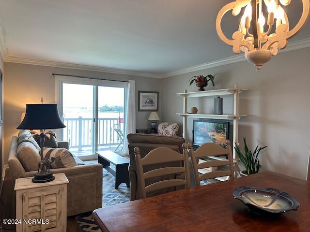 dining area with crown molding and a chandelier