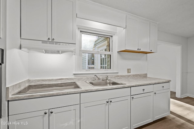 kitchen featuring dark hardwood / wood-style flooring, sink, white cabinets, and black electric cooktop