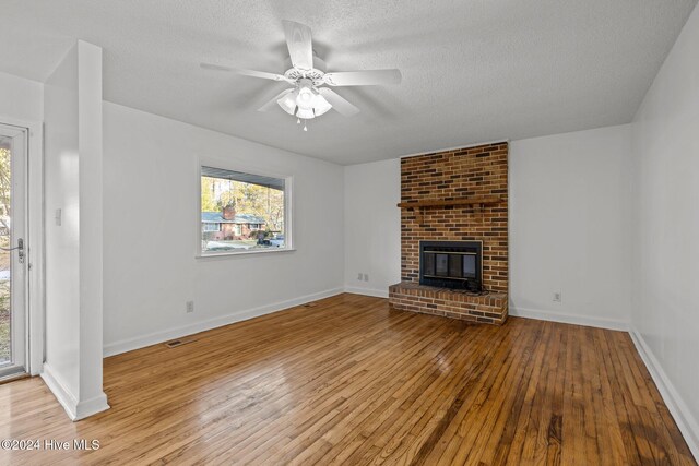 unfurnished living room with plenty of natural light, ceiling fan, a textured ceiling, and light hardwood / wood-style flooring