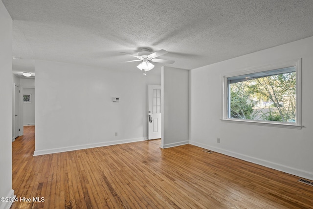 spare room featuring ceiling fan, light hardwood / wood-style flooring, and a textured ceiling