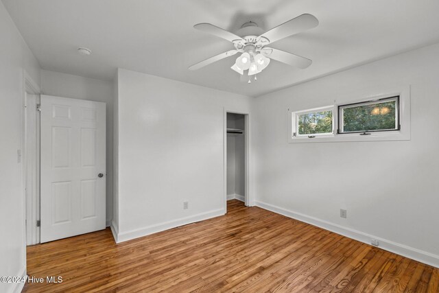 unfurnished bedroom with a closet, light hardwood / wood-style floors, and ceiling fan