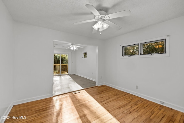 empty room with ceiling fan, a textured ceiling, and hardwood / wood-style flooring